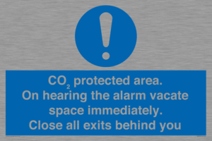 MN7906: CO₂ protected area. On hearing the alarm vacate space immediately. Close all exits behind you