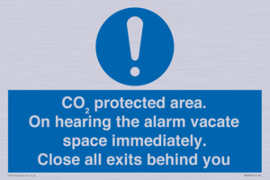 MN7906: CO₂ protected area. On hearing the alarm vacate space immediately. Close all exits behind you